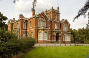 A view of Weelsby hall, through the tress and across the lawn.